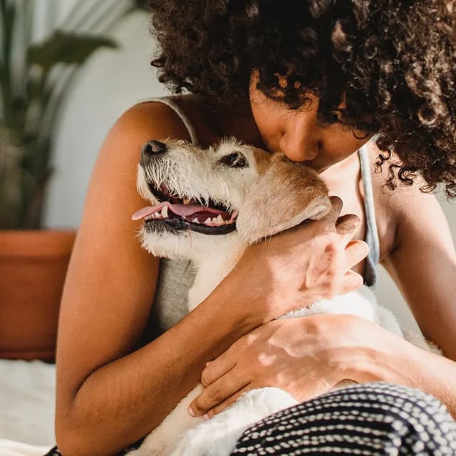 woman hugging dog to rehome